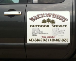 A truck with a sign that says backwoods outdoor service.