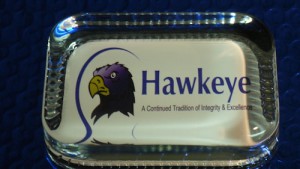 Hawkeye logo on a glass cube.