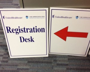 Two registration desk signs next to each other.