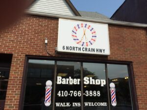 Exterior of a barber shop with a sign reading 